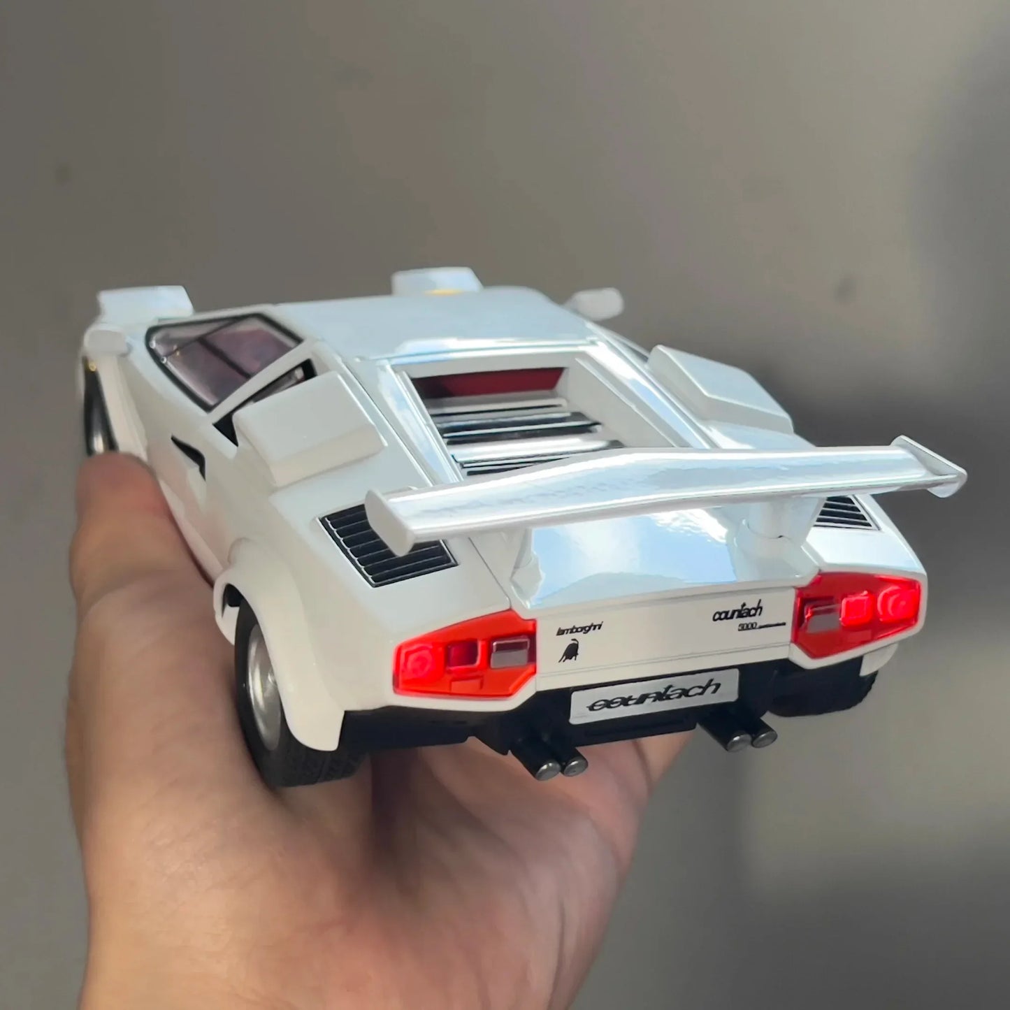 White Lamborghini Countach model car with a rear spoiler and detailed design.